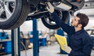 Auto car repair service center. Mechanic examining car